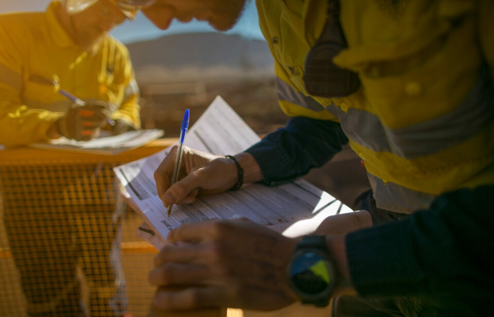 Construction miner supervisor wearing  safety glove signing work